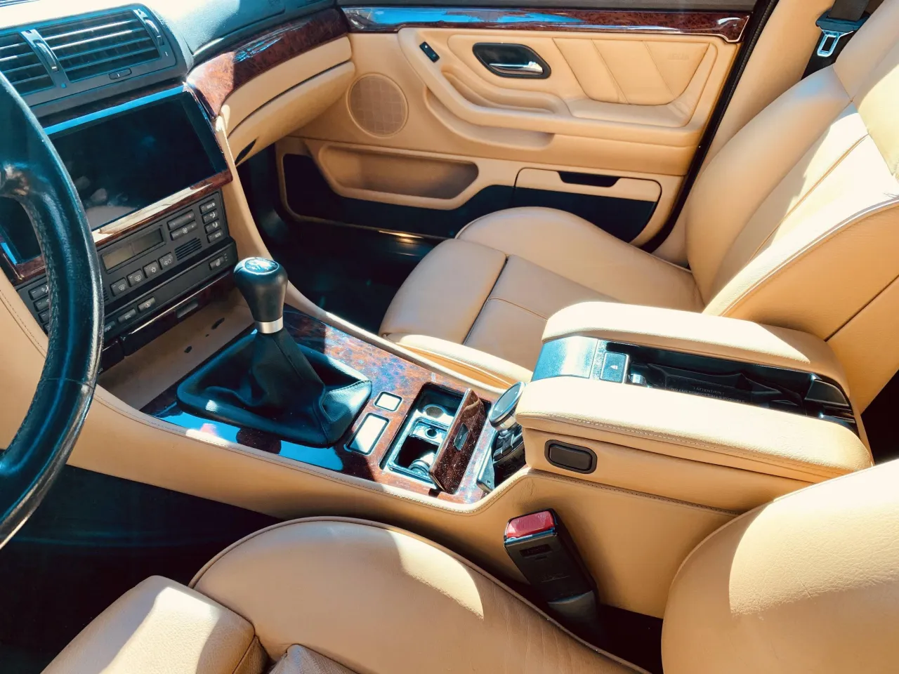 Wnętrze BMW E38 Long w beżowej sk&oacute;rze, z drewnianymi wstawkami i automatyczną skrzynią bieg&oacute;w.