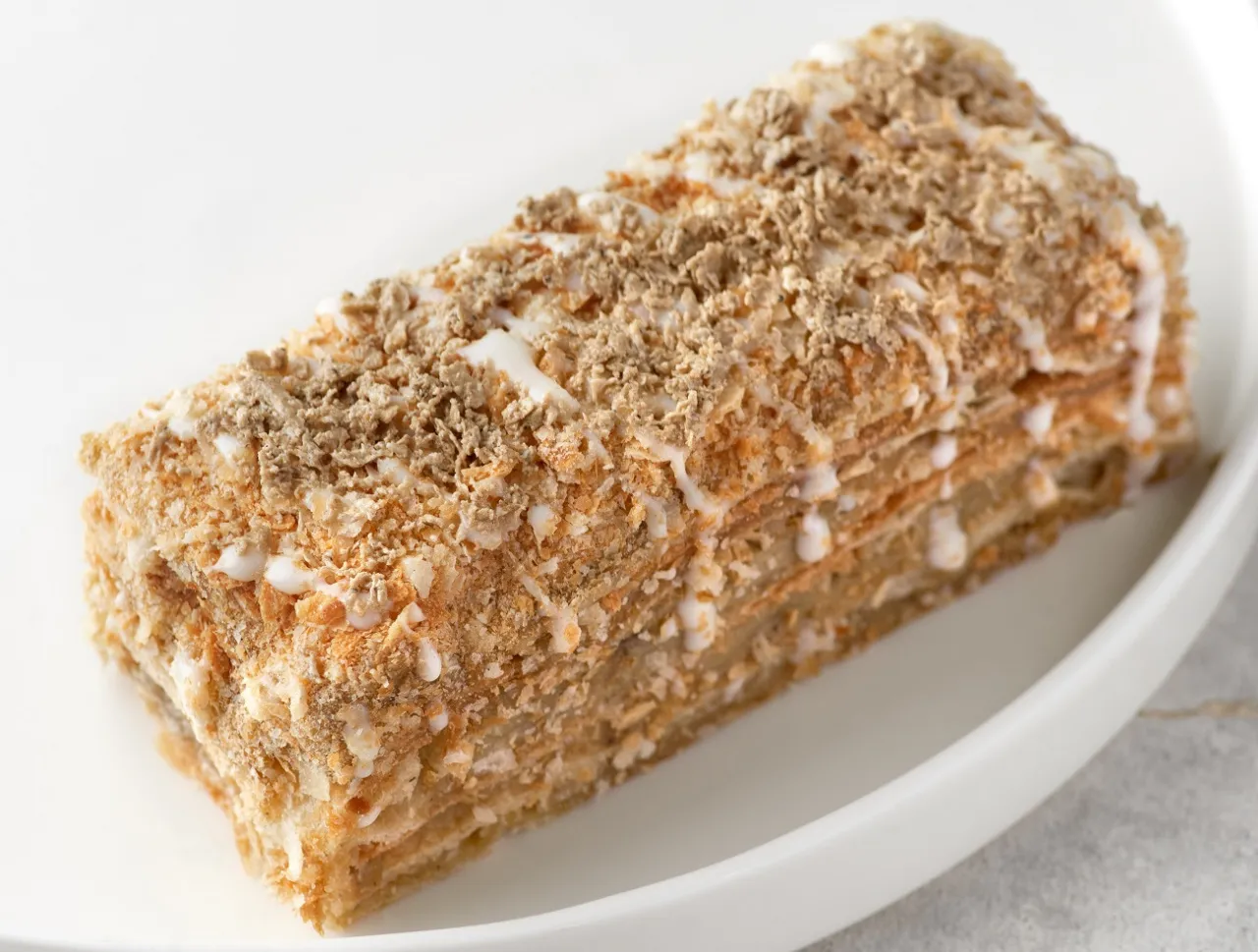 Pyszne ciasto z warstwami ciasta francuskiego i kremem chałwowym, posypane kruszonką. Idealne na deser, gdy szukasz inspiracji na przepis na ciasto z masą chałwową.