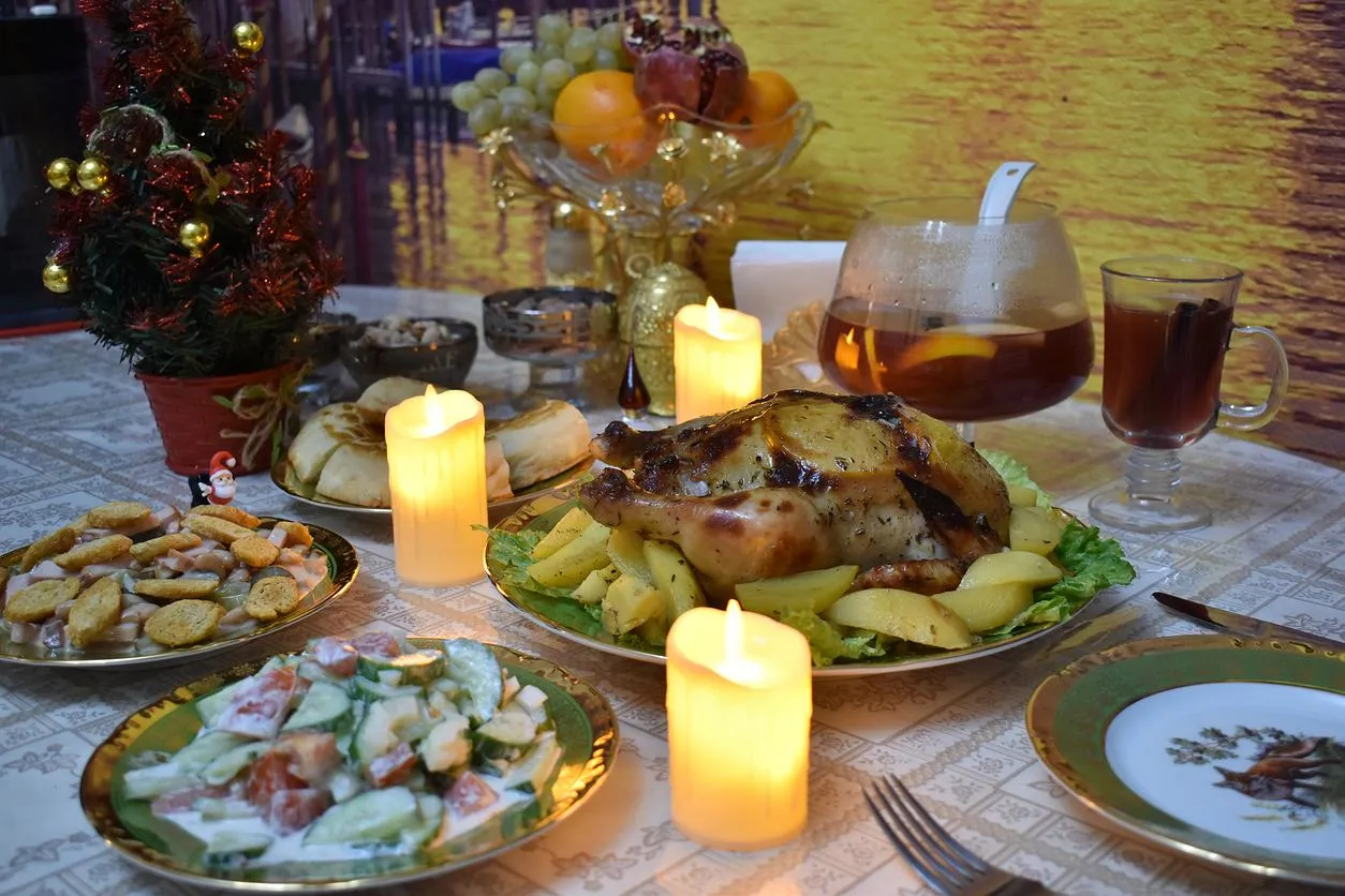 Co zrobić na świąteczny obiad? Pieczony kurczak z ziemniakami, sałatki, owoce i gorący nap&oacute;j przy blasku świec.