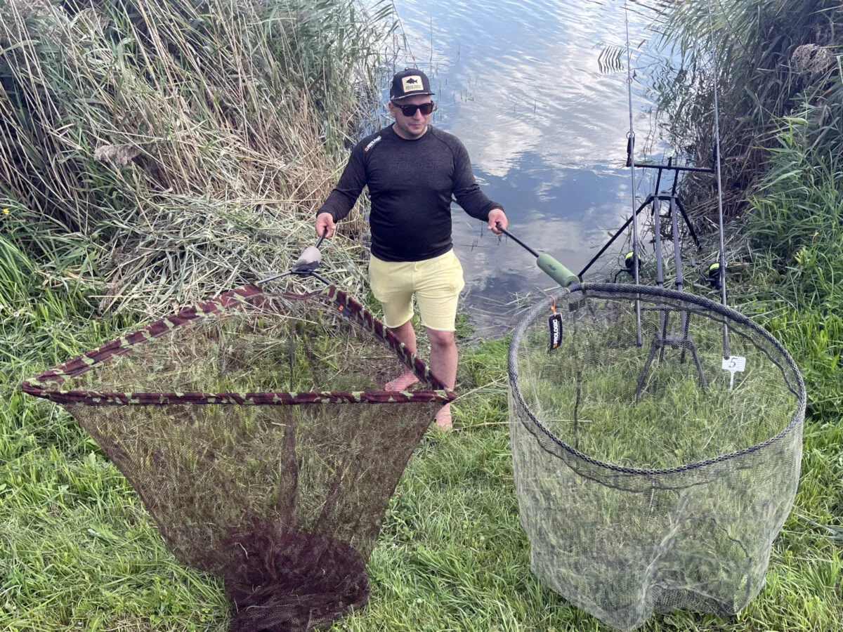 wędkarz z matą karpiową i podbierakiem