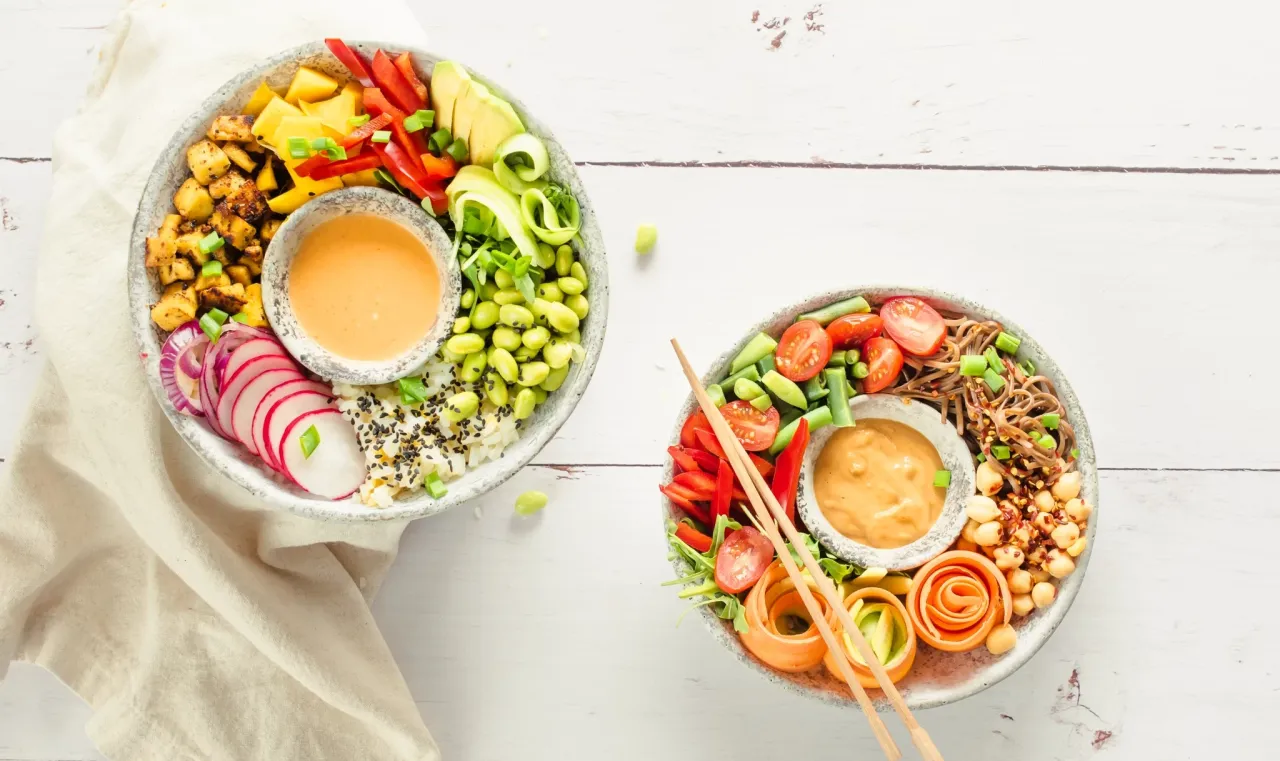 Dwa kolorowe bowl z ryżem, warzywami i sosem. Idealny przepis na zdrowy lunch.