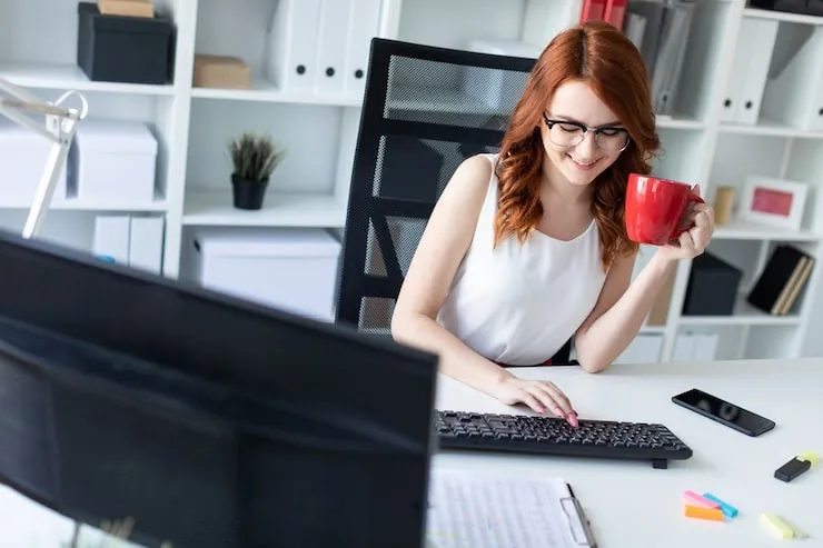 Młoda osoba pracująca przy komputerze w biurze