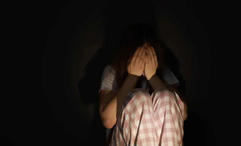 Osoba odczuwająca lęk w ciemnym pomieszczeniu