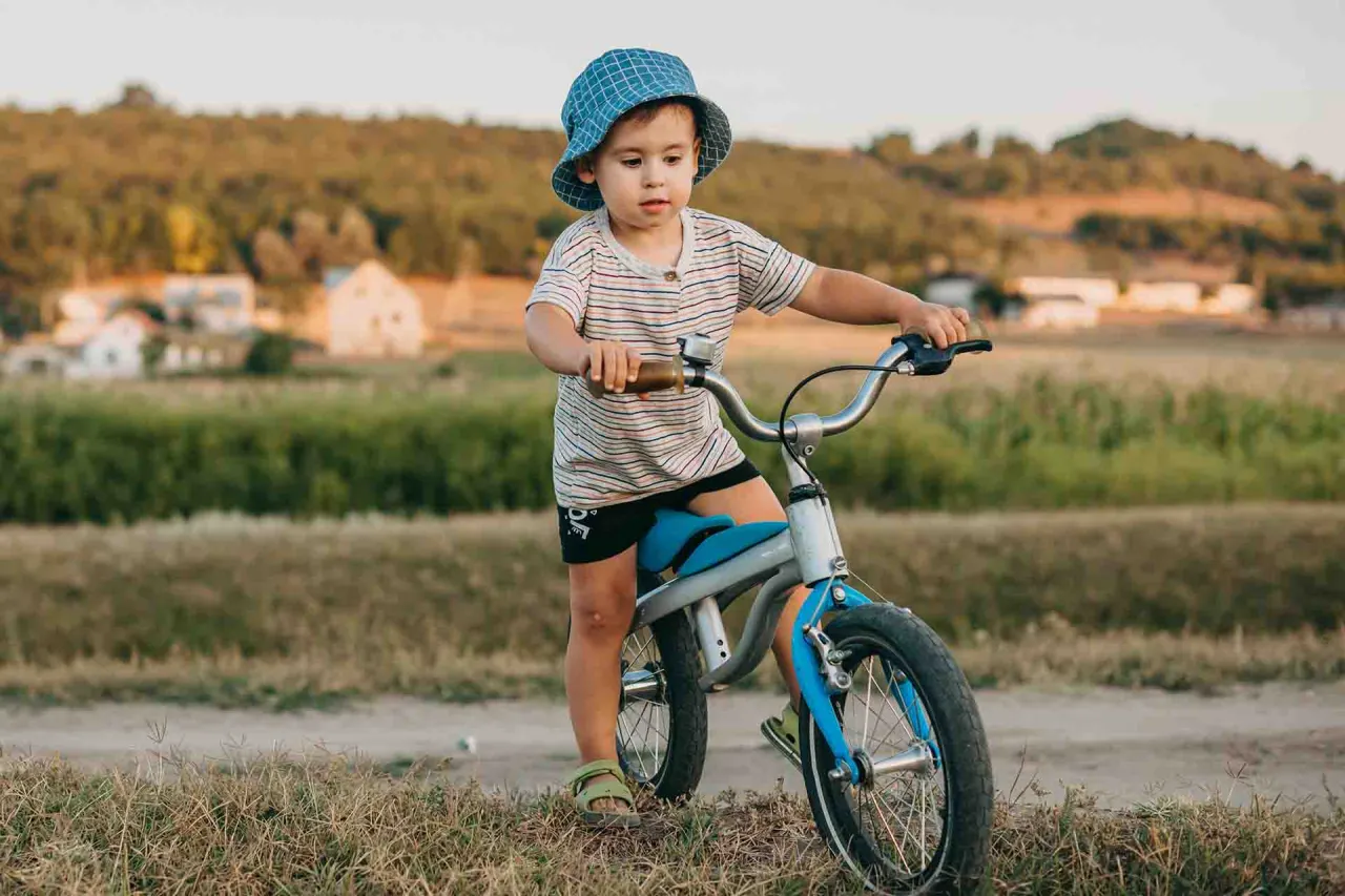 Dziecko na rowerku biegowym uśmiechnięte