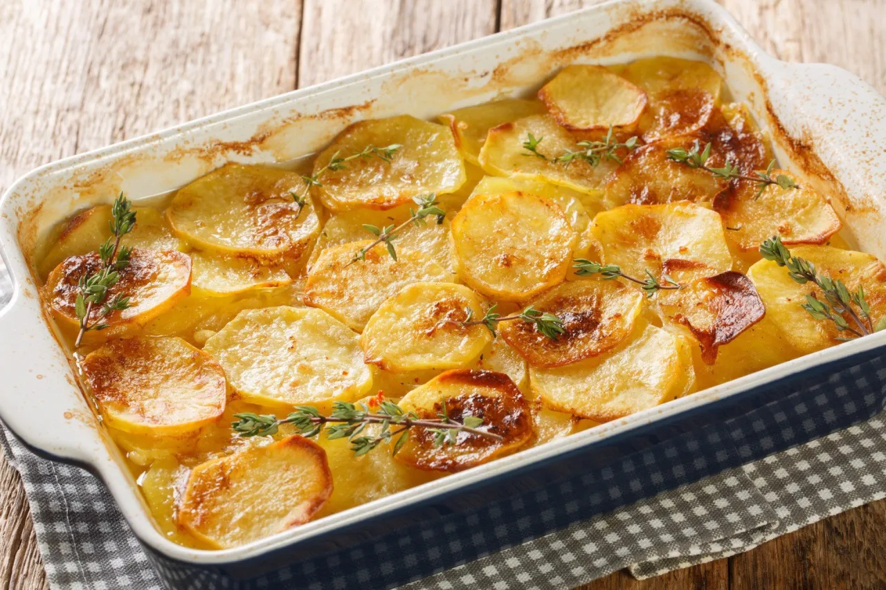 Złociste plasterki ziemniak&oacute;w zapiekane z ziołami. Idealne jako baza do sosu do zapiekanki ziemniaczanej.