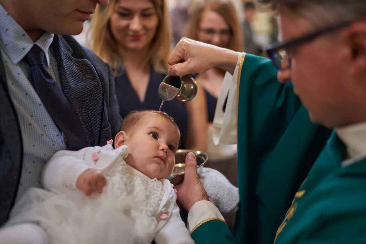 Chrzciny dziecka, rodzice z dzieckiem w kościele
