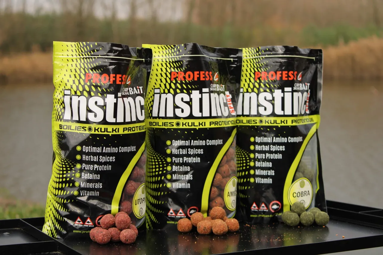 Trzy opakowania kulek proteinowych Profish Instinct, idealnych do nauki jak łowić na kulki proteinowe. Na pierwszym planie widać kilka kulek.