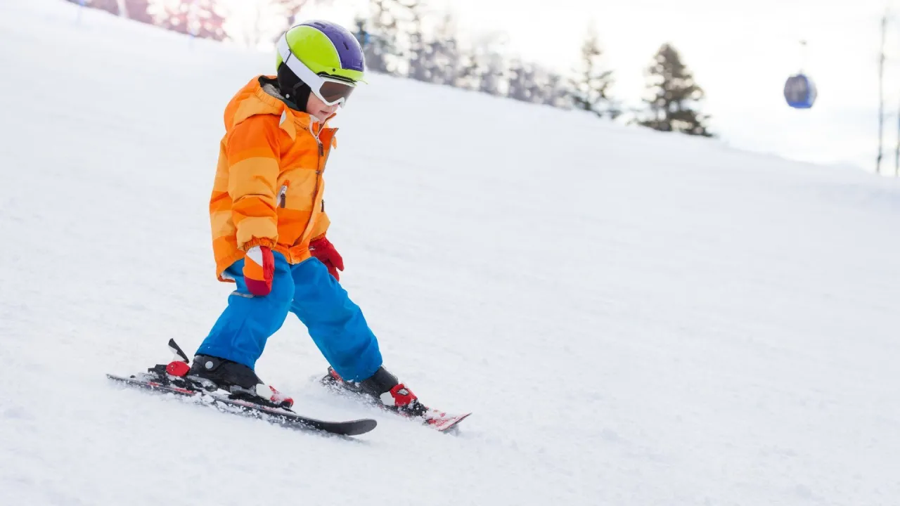 Dzieci uczące się jeździć na nartach na oślej łączce