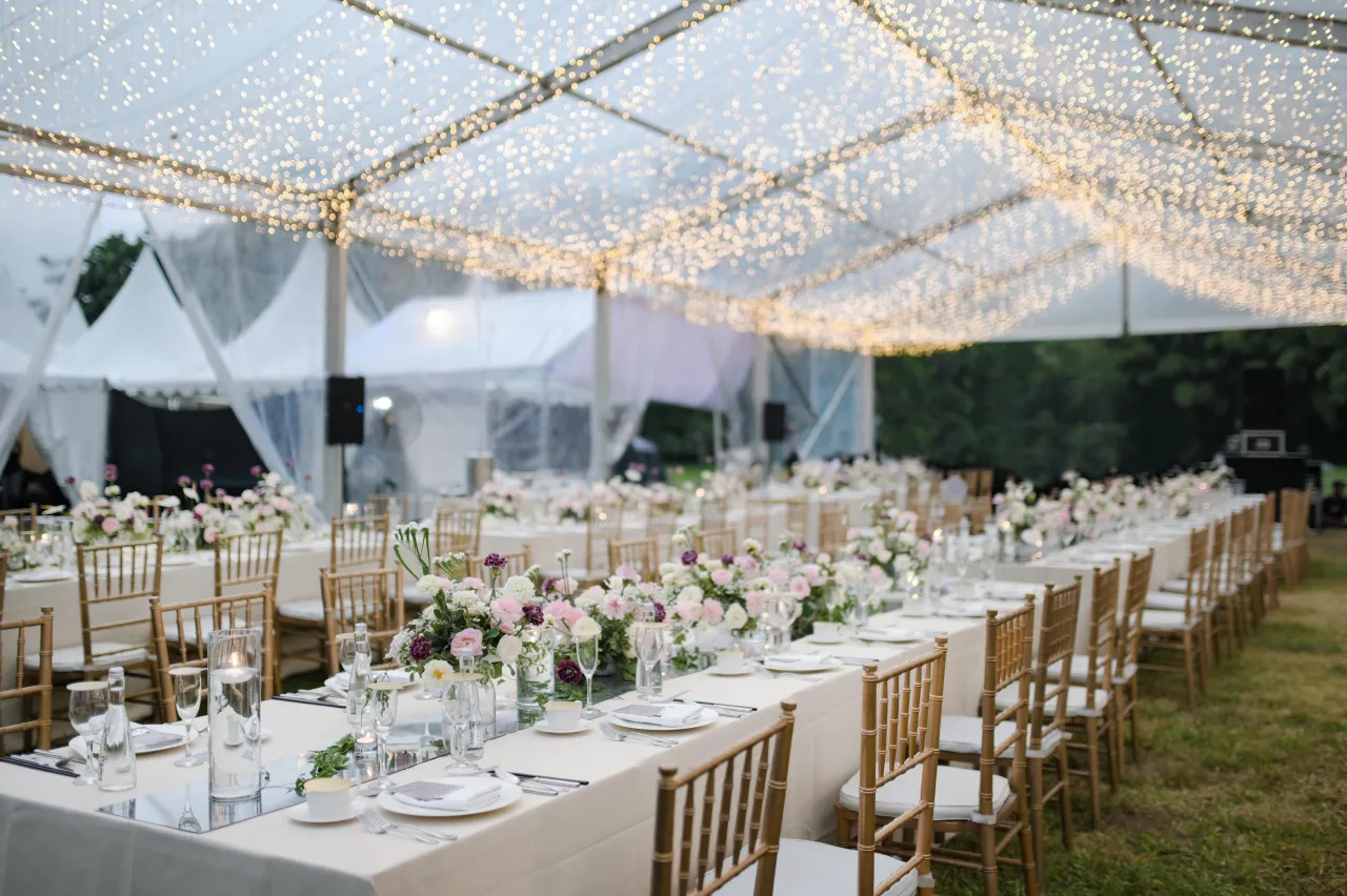 Uroczyste przyjęcie pod namiotem z mnóstwem światełek. Różnica między ślubem w plenerze a weselem w stodole logistyka i plan b.