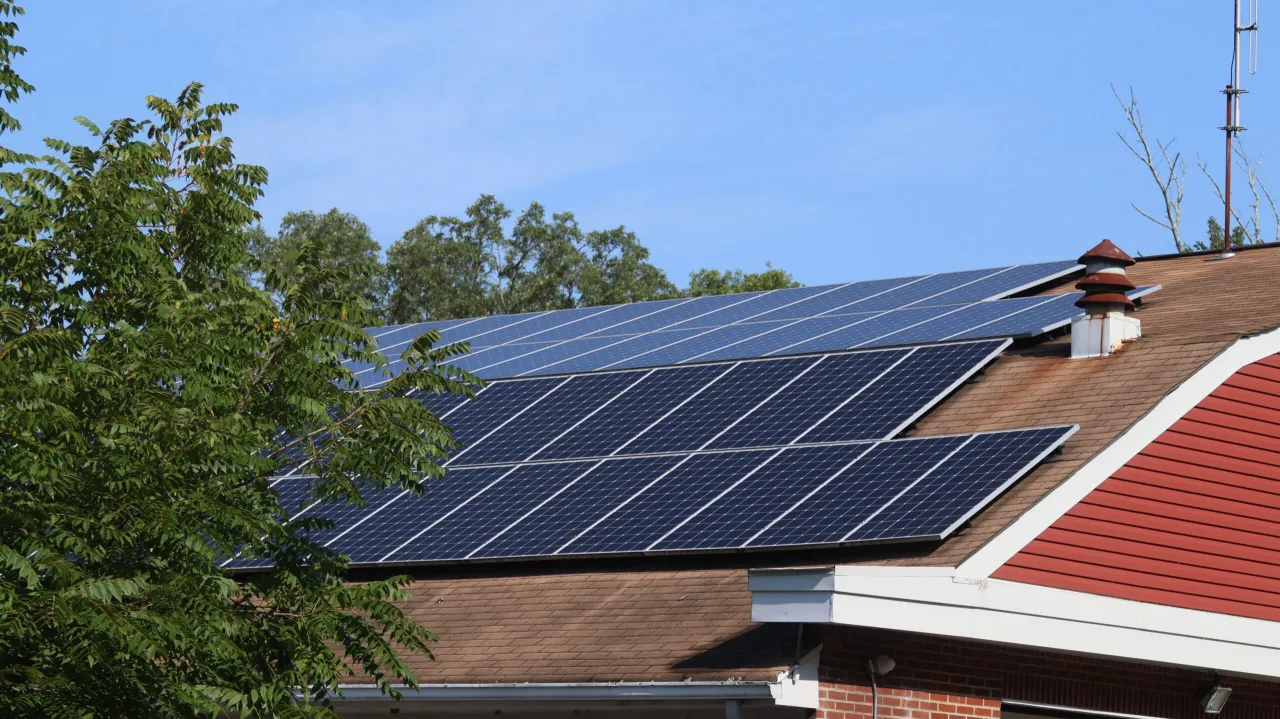 Panele fotowoltaiczne na dachu domu, licznik energii, rachunek za prąd