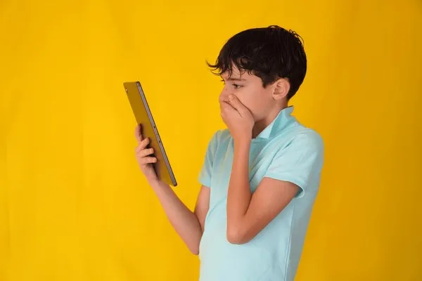 Osoba zamyślona, patrząca na smartfon, z lekkim niepokojem