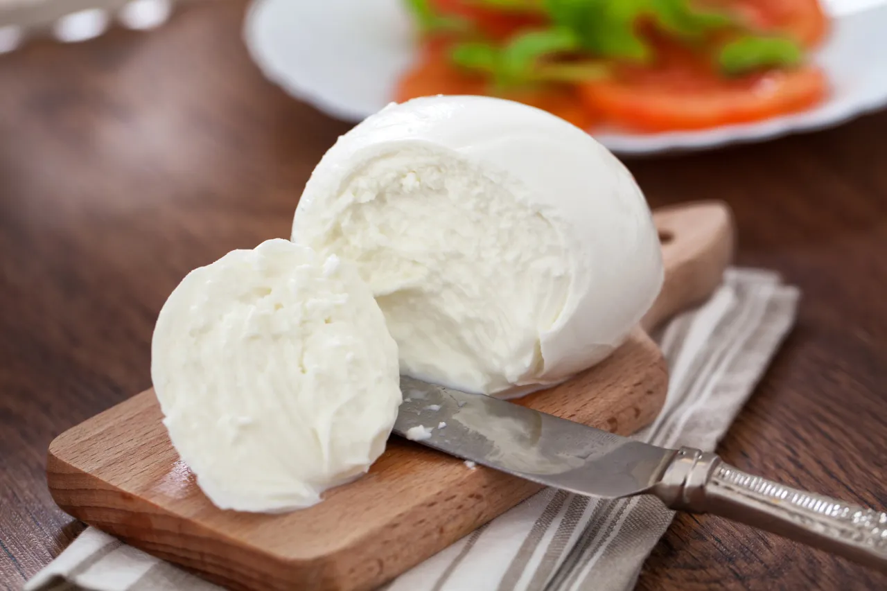 Świeża mozzarella na desce, gotowa do sałatki. Zastanawiasz się, ile tłuszczu ma mozzarella?