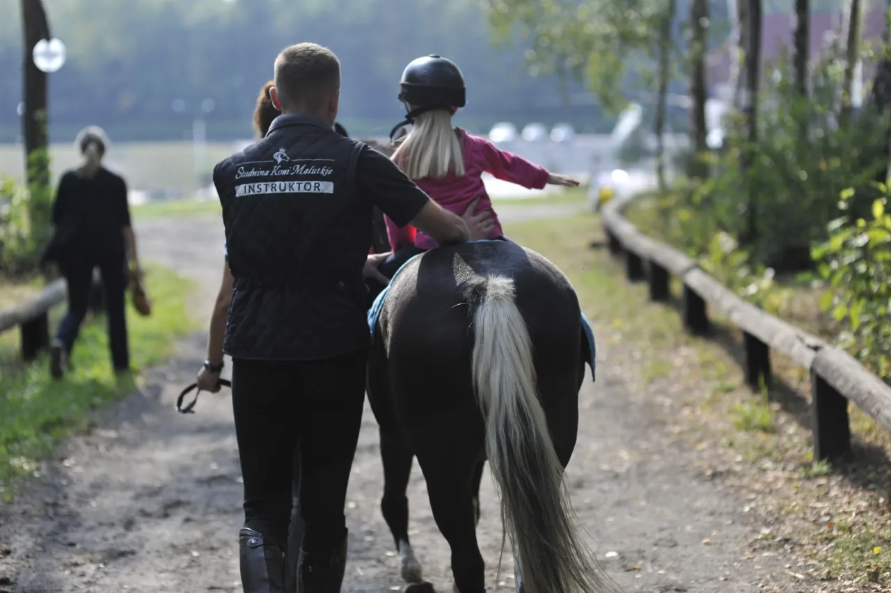 Dzieci jeżdżące na kucykach w stadninie