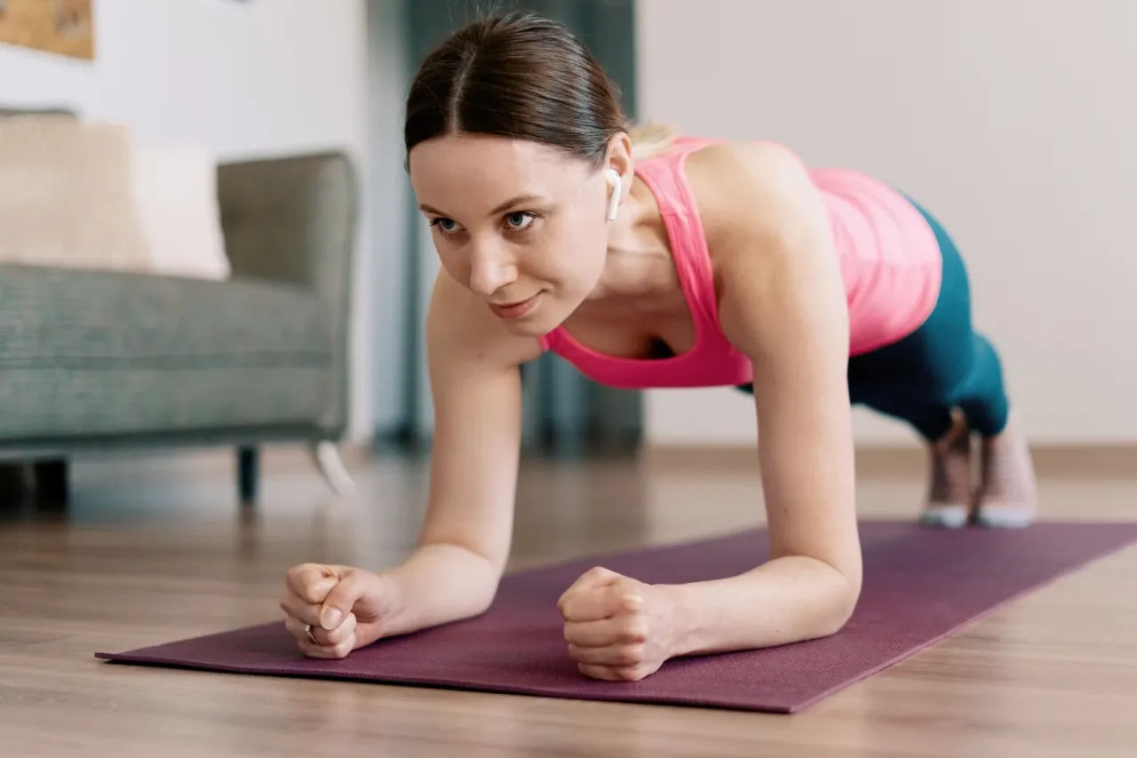 kobieta wykonująca deskę w domu