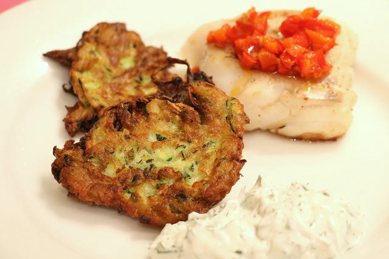 placki z cukinii na talerzu z sosem