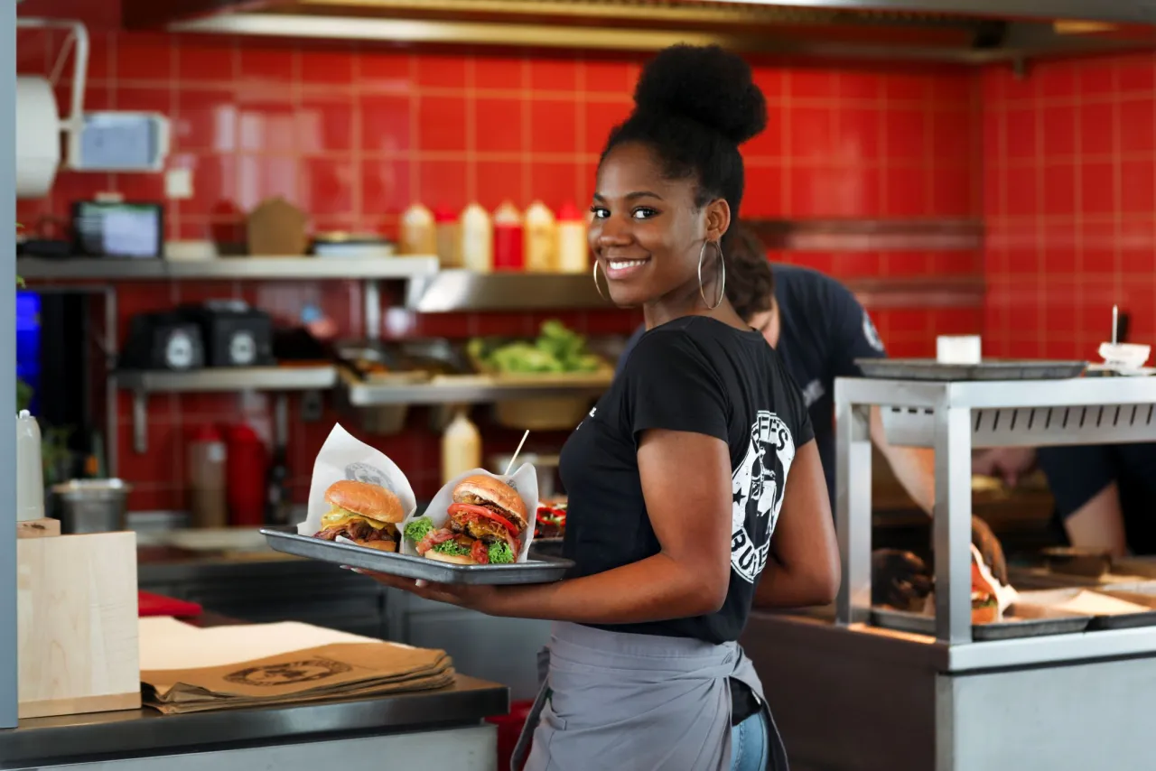 Hamburger Koch bei der Arbeit oder Servicekraft im Restaurant