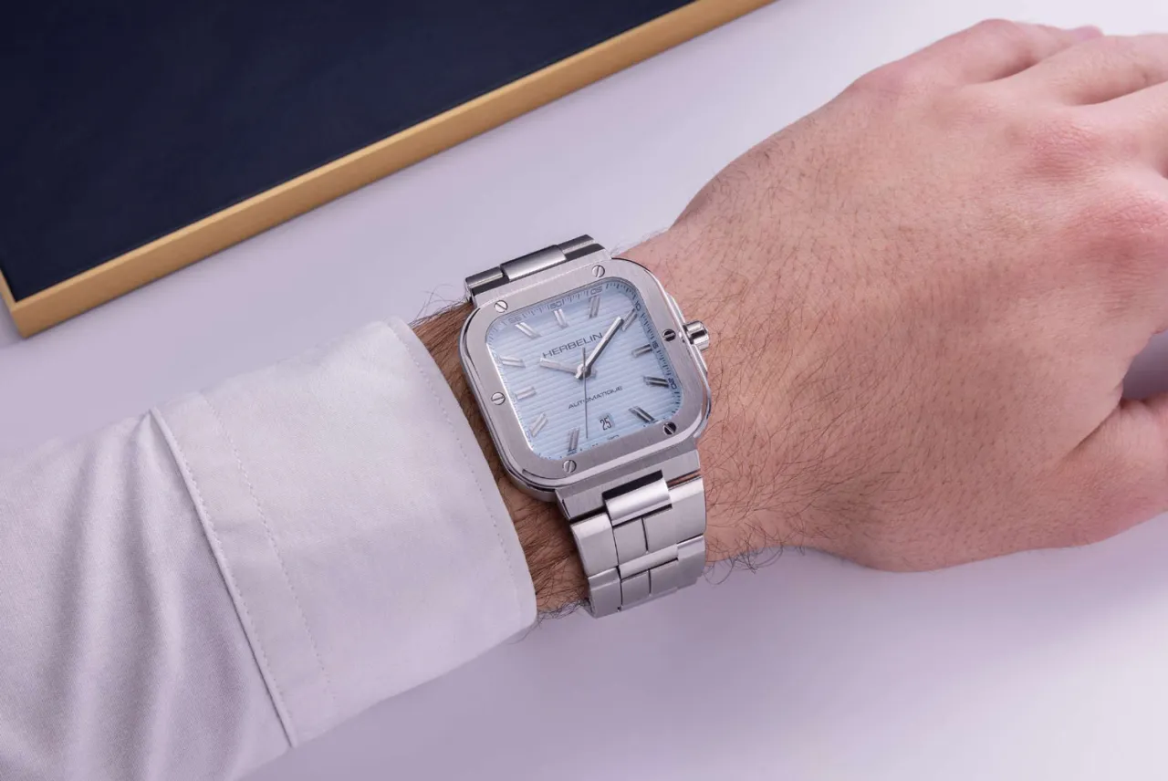 Męski kwadratowy zegarek na bransolecie na nadgarstku z bliska