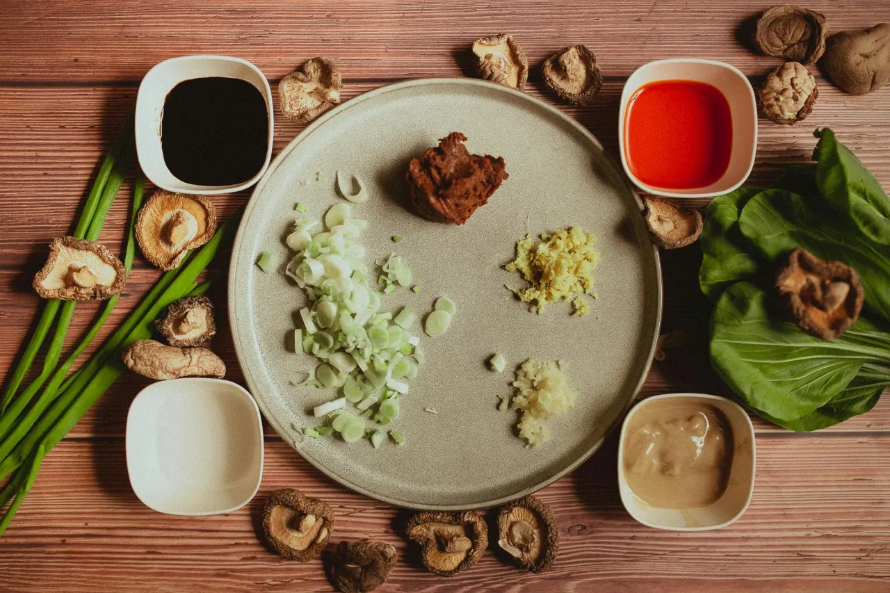 Składniki na szybki ramen: sos sojowy, pasta miso, imbir, czosnek, dymka, grzyby shiitake, pak choi i sos sezamowy.