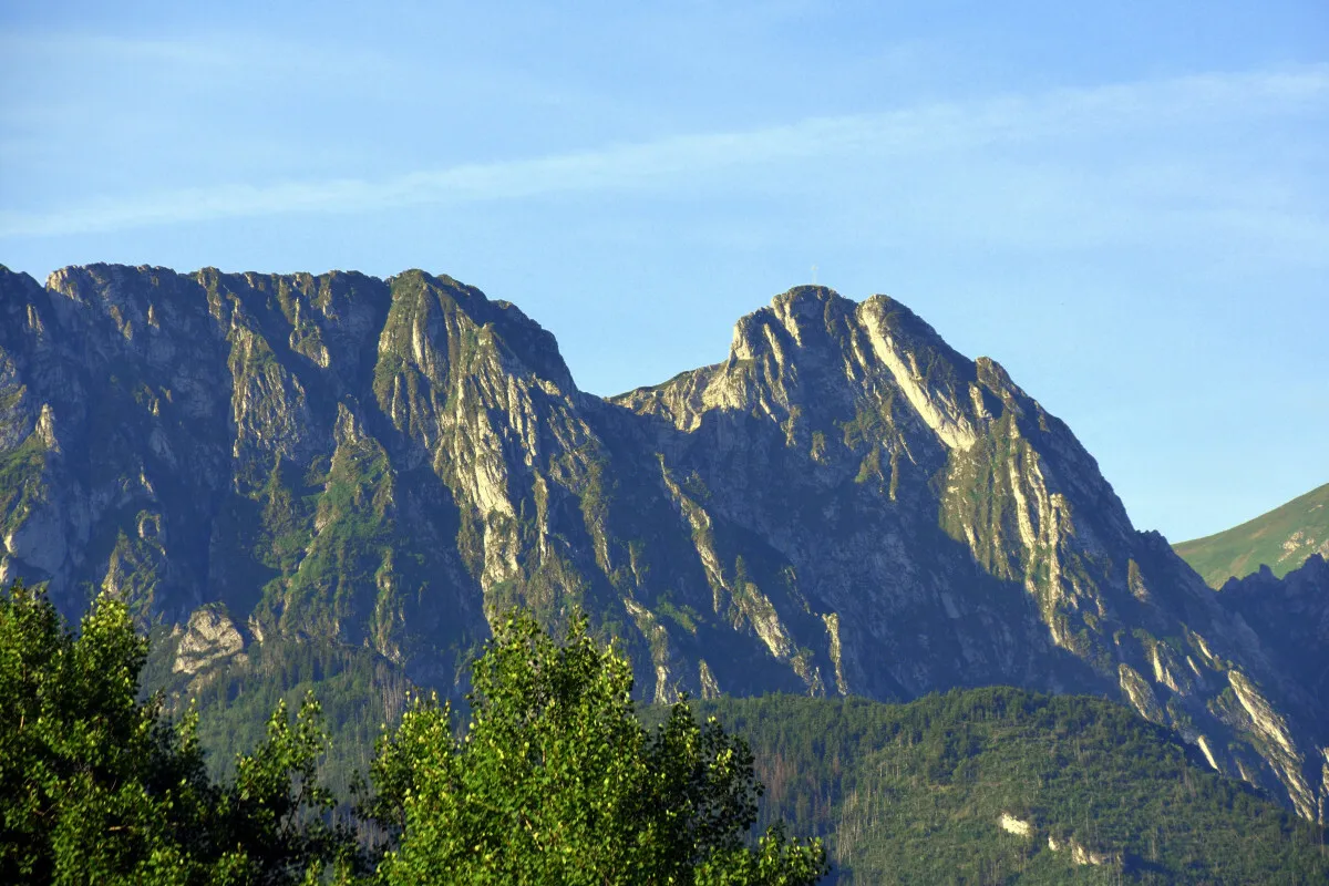 Majestatyczne g&oacute;ry, niczym śpiący rycerz, czuwają nad doliną. Ich skaliste zbocza, porośnięte zielenią, tworzą krajobraz jak z legendy.