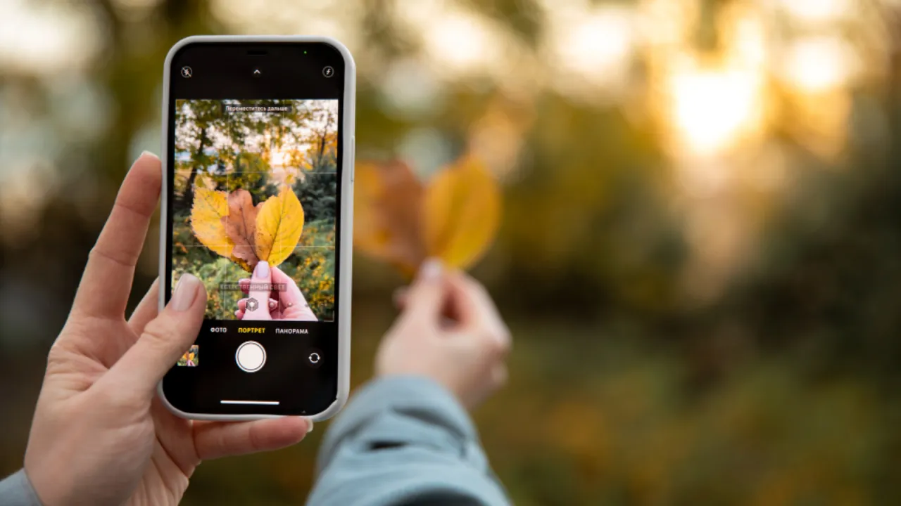 Osoba robiąca zdjęcie smartfonem przy oknie