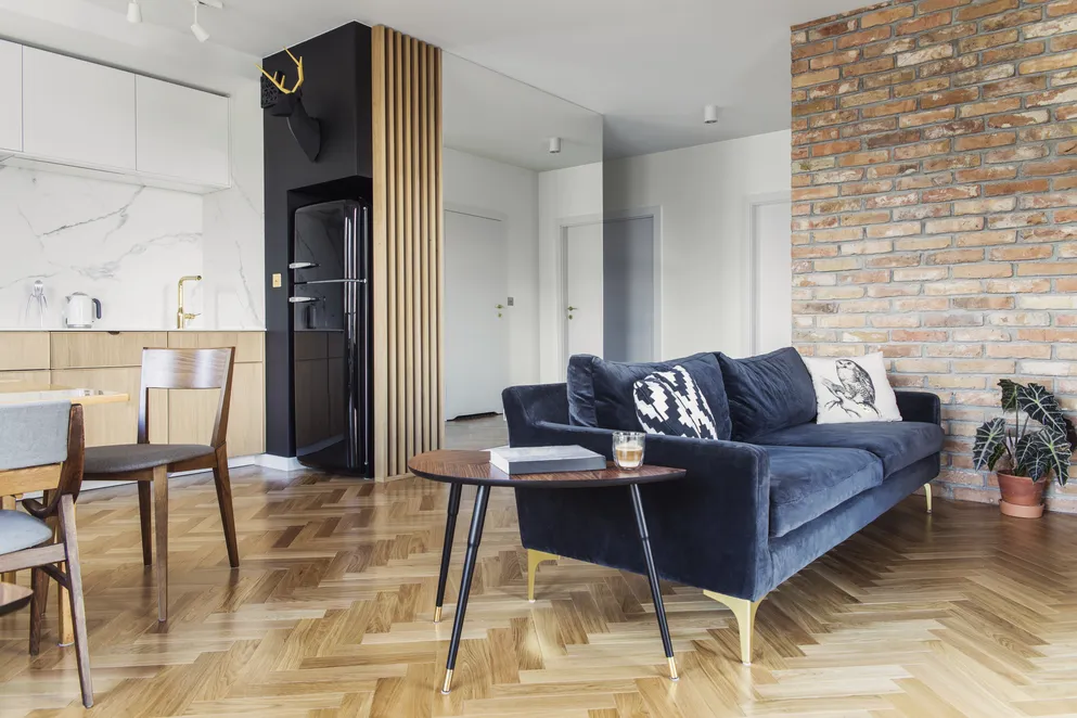 ściana ceglana za kanapą granatową inspiracje