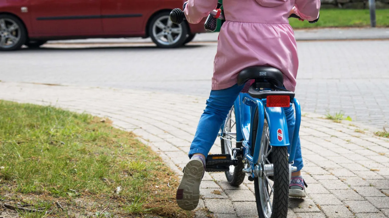 Kind auf Fahrrad, das die Füße auf den Boden bekommt