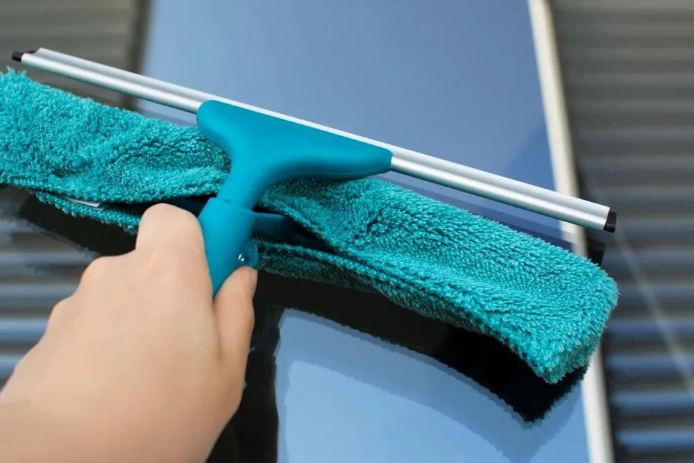 narzędzia do mycia okien: ściągaczka, mikrofibra, wiadro z wodą