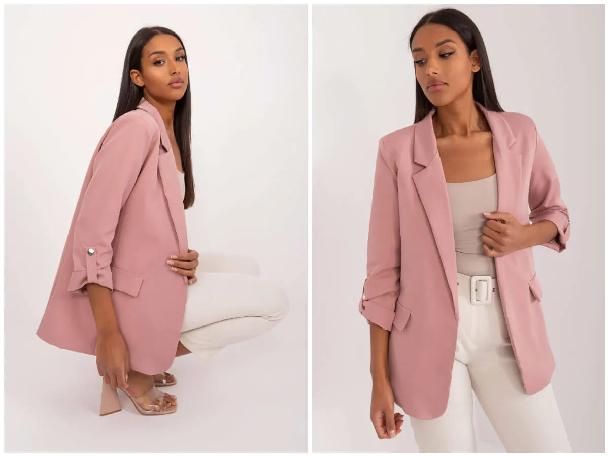 Modelka prezentuje r&oacute;żową marynarkę i białe spodnie. Idealna stylizacja, jeśli zastanawiasz się, jaka bluzka do marynarki pasuje.