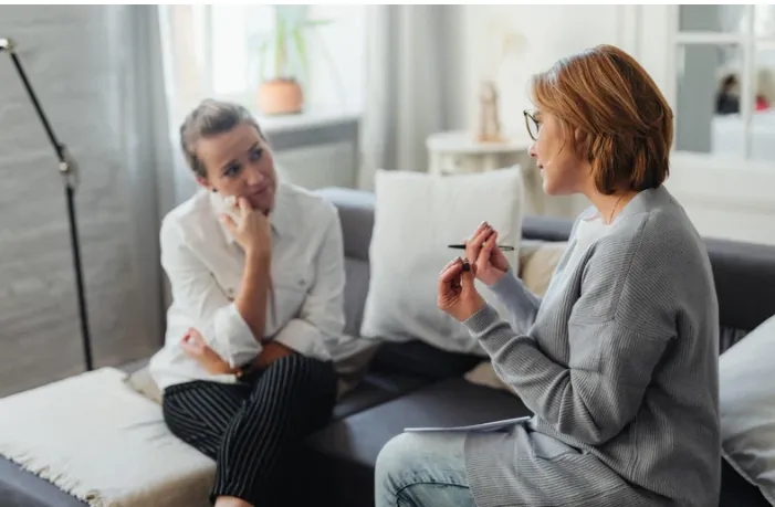 terapeuta rozmawiający z pacjentem w gabinecie, symbolizujący psychoterapię