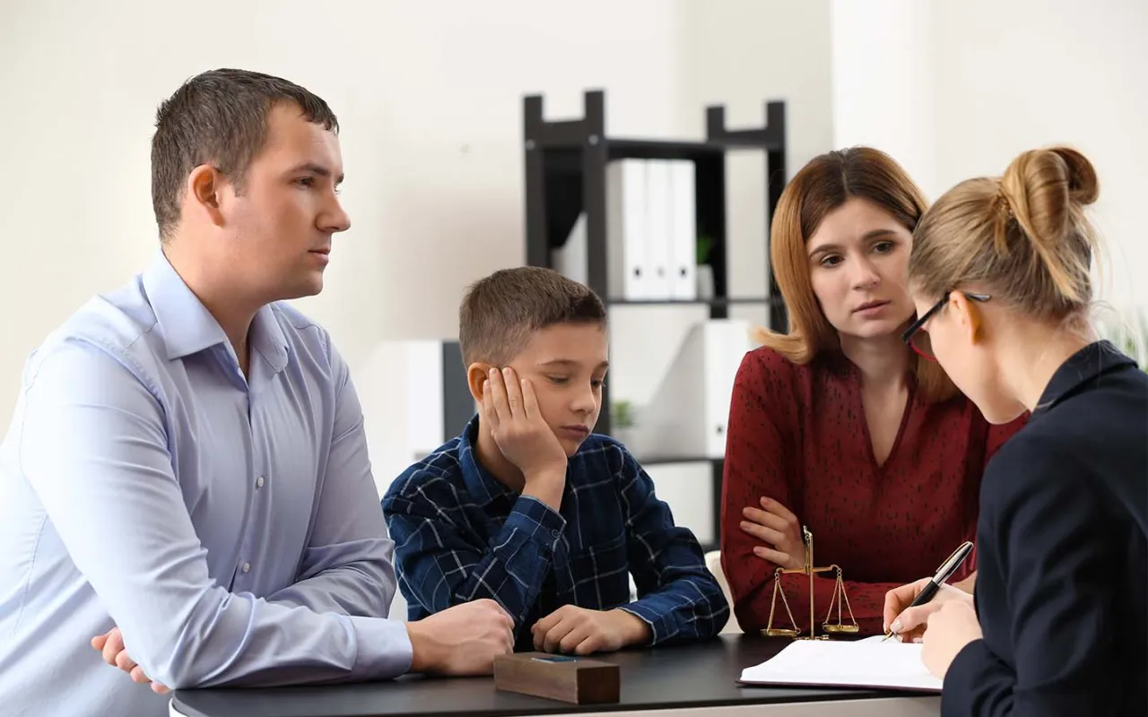 Rodzice z synem rozmawiają z prawniczką. Kto to kurator? To osoba, która reprezentuje dziecko w sprawach sądowych.