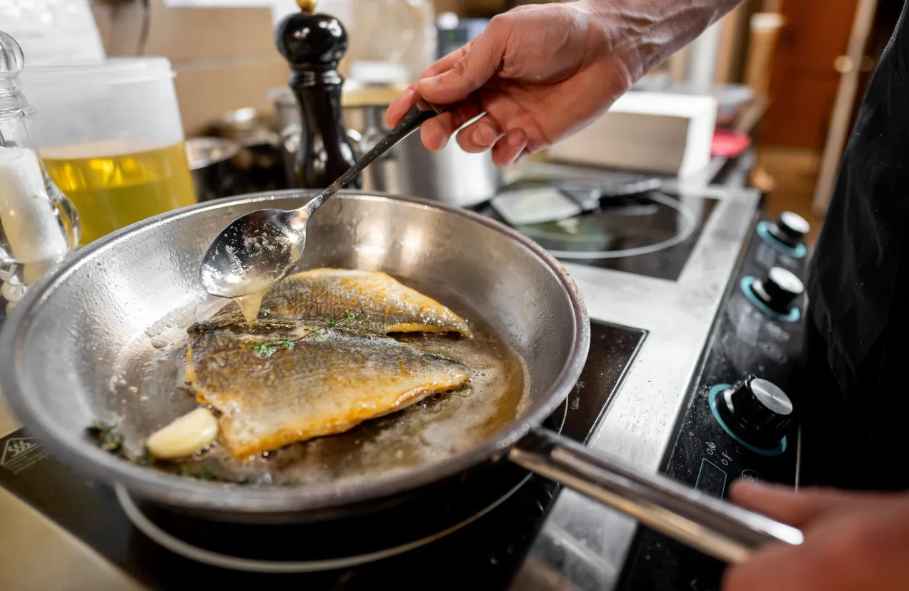 Rybę smaży się na patelni z masłem i czosnkiem.