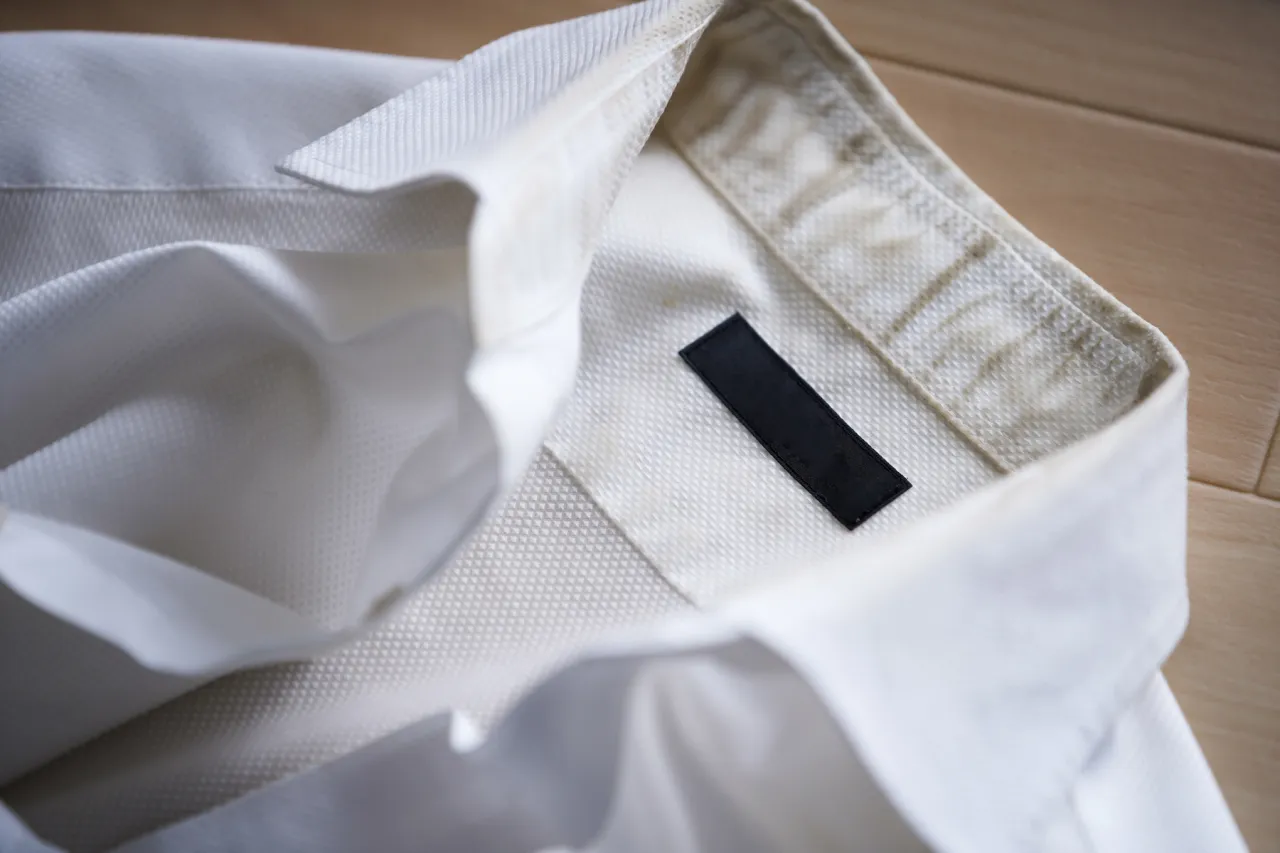 Zżółknięty kołnierzyk białej koszuli. Dowiedz się, jak wybielić koszulę i przywrócić jej dawny blask.