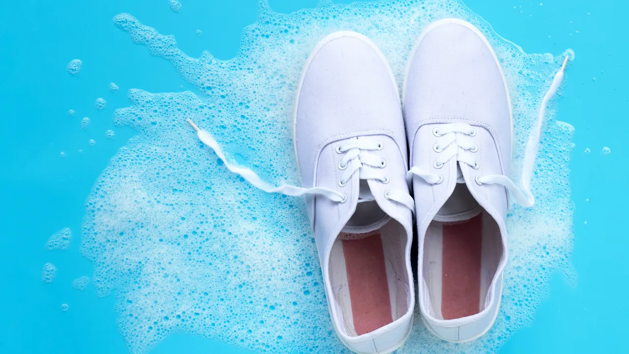 Osoba w rękawiczkach i masce wybielająca buty