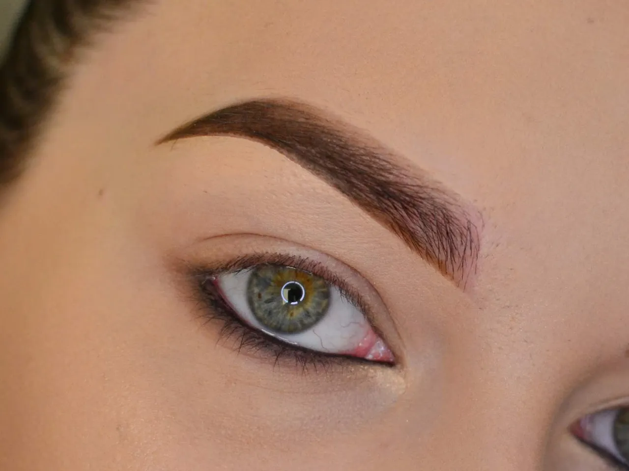 Delikatny makijaż rozświetlający oko, podkreślający zieloną tęczówkę. Perfekcyjnie wyrysowana brew.