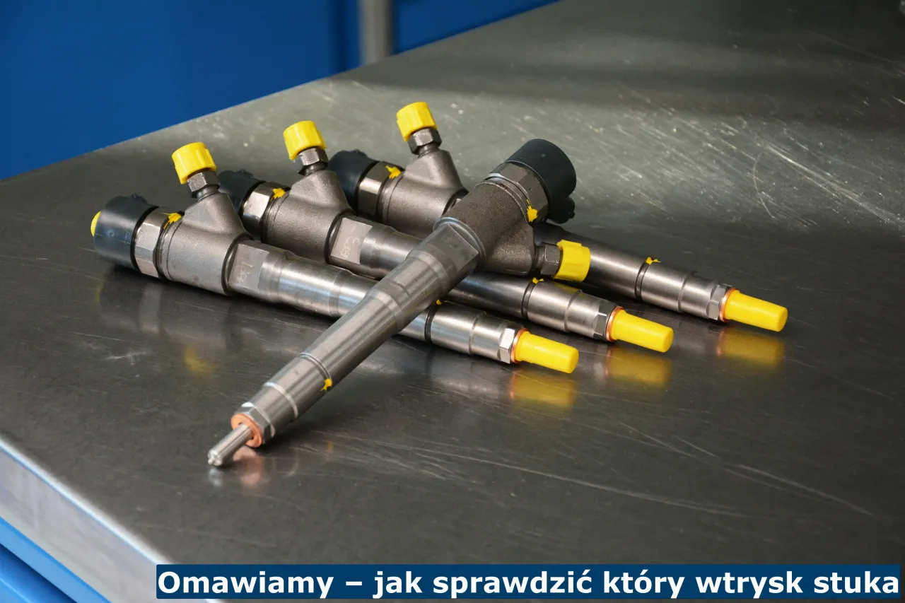 Kilka wtryskiwaczy do silnika diesla leży na metalowym blacie. Pomagają zdiagnozować problem cykania w silniku diesel.