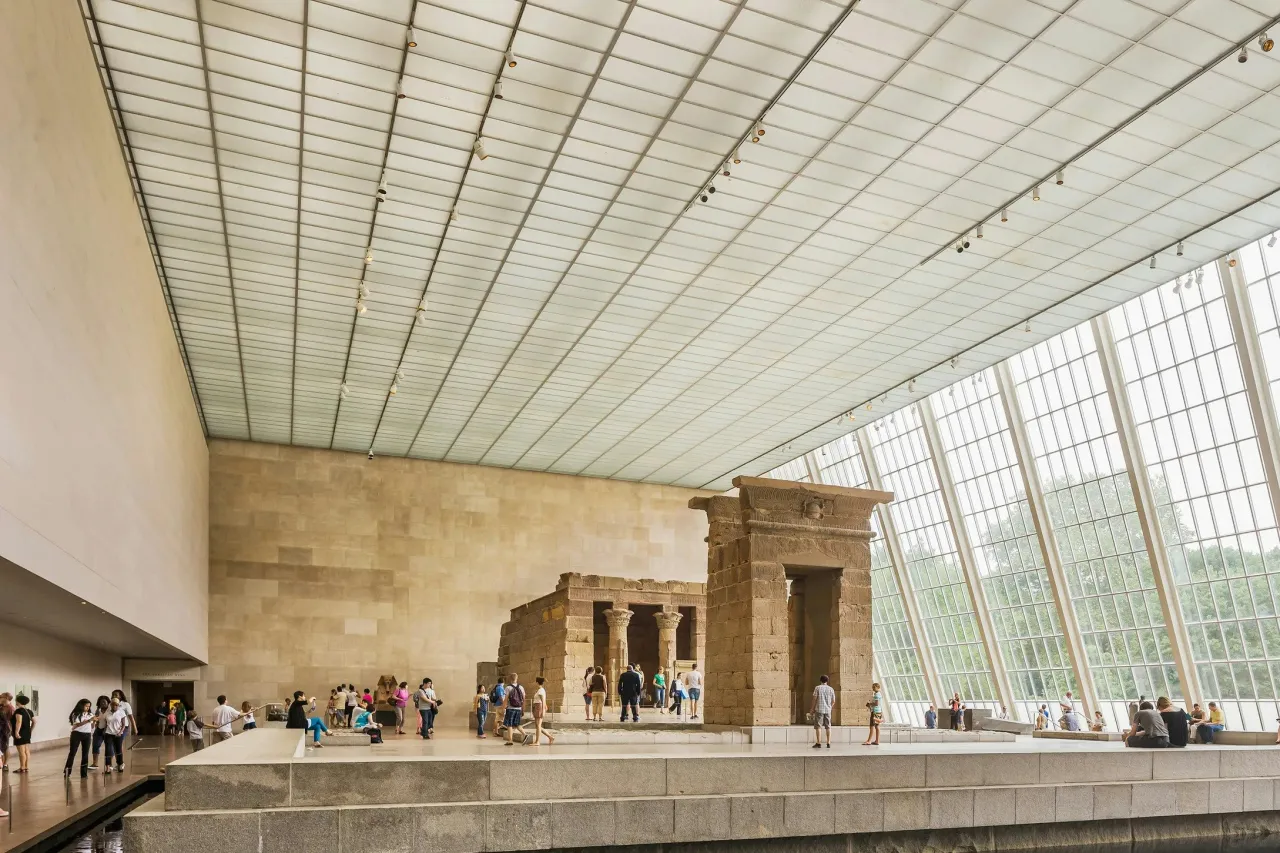 Zwiedzający podziwiają egipską świątynię w Met w Nowym Jorku. Ogromne okna wpuszczają światło do muzeum.