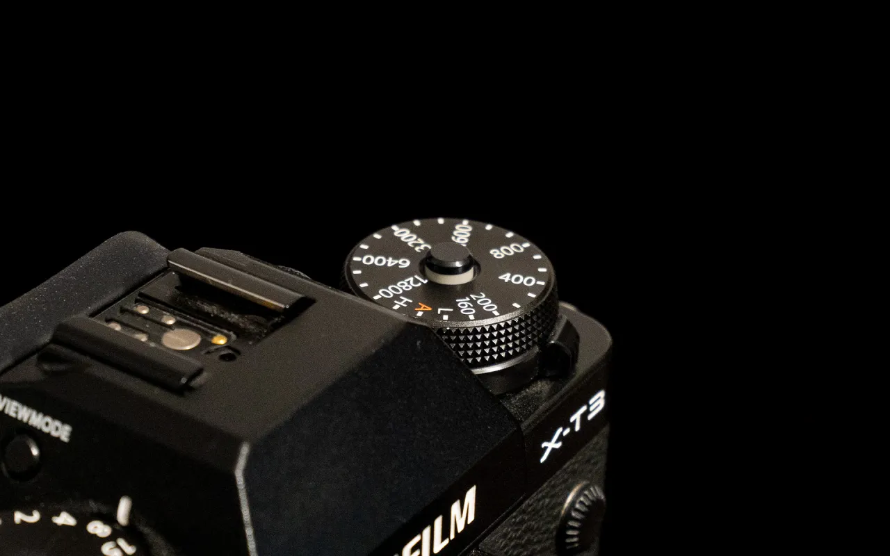 Pokrętło ISO na aparacie Fujifilm X-T3 pokazuje, jak ustawić iso w aparacie. Widoczne wartości to 160, 200, 400, 800, 600, 3200, 6400, 12800.