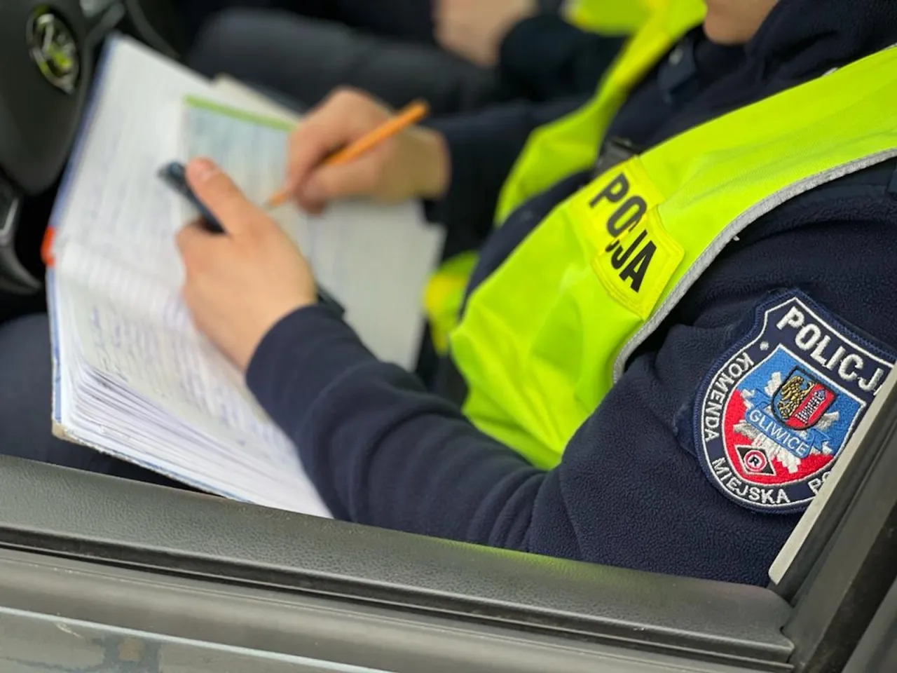 Policjant przeprowadza badanie alkomatem