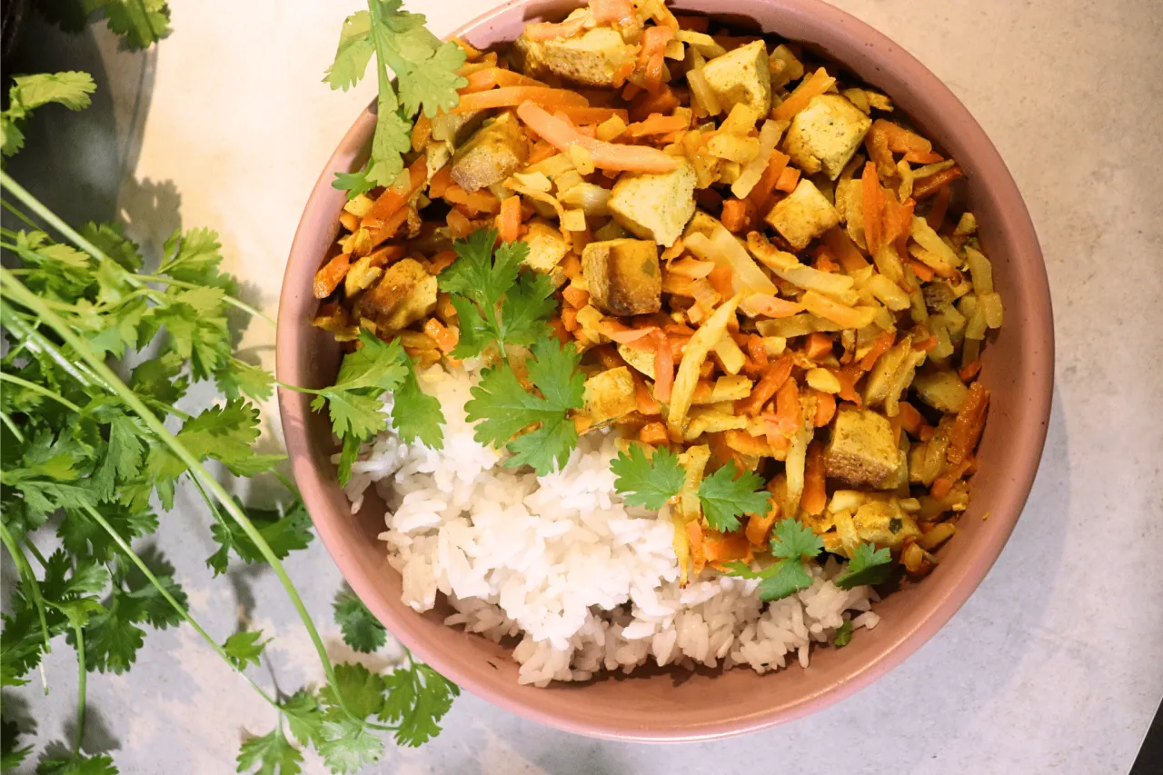 Pyszne danie co na obiad bez mięsa: ryż z warzywami i tofu, posypane świeżą kolendrą.