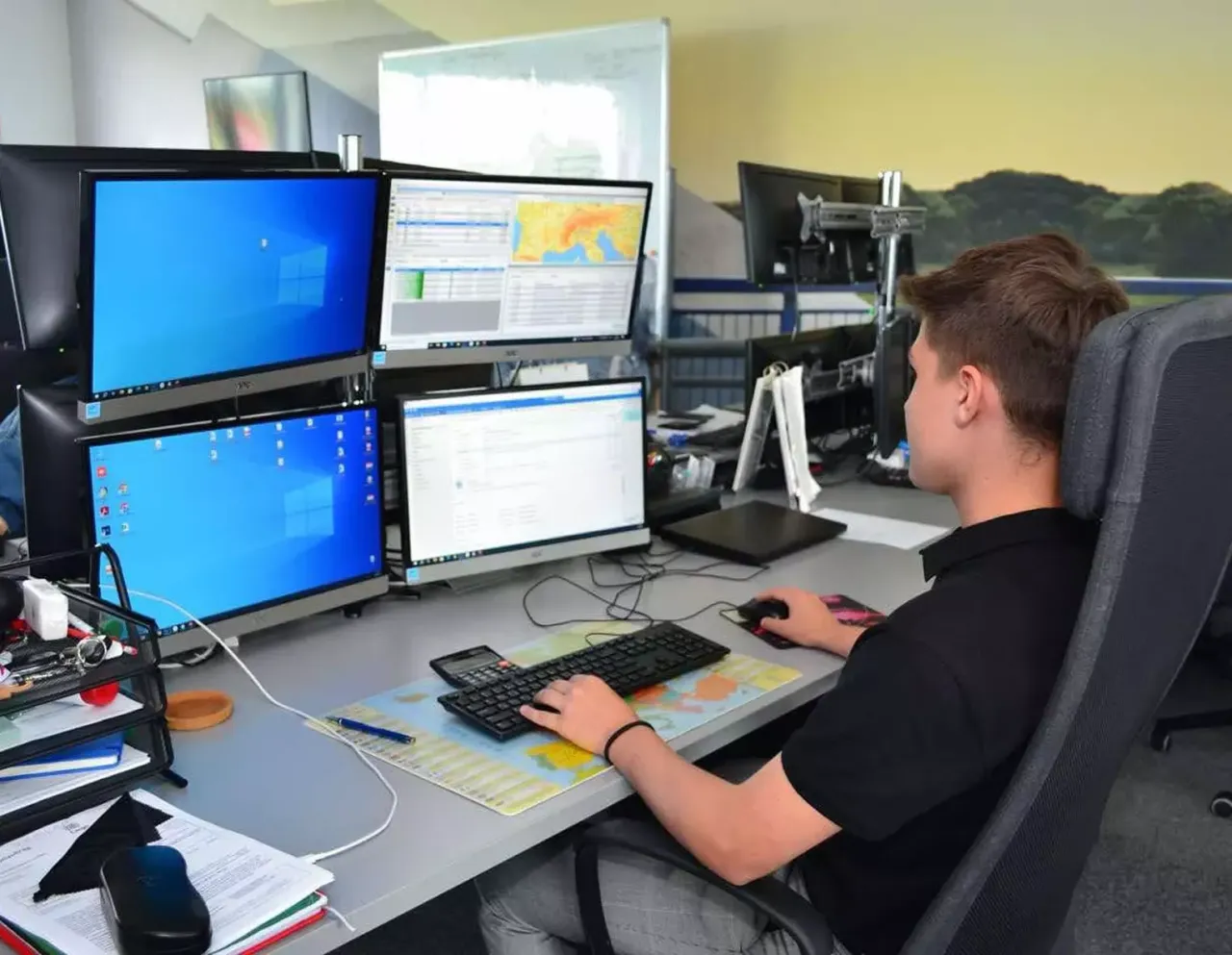 Spedytor przy biurku z telefonem i komputerem