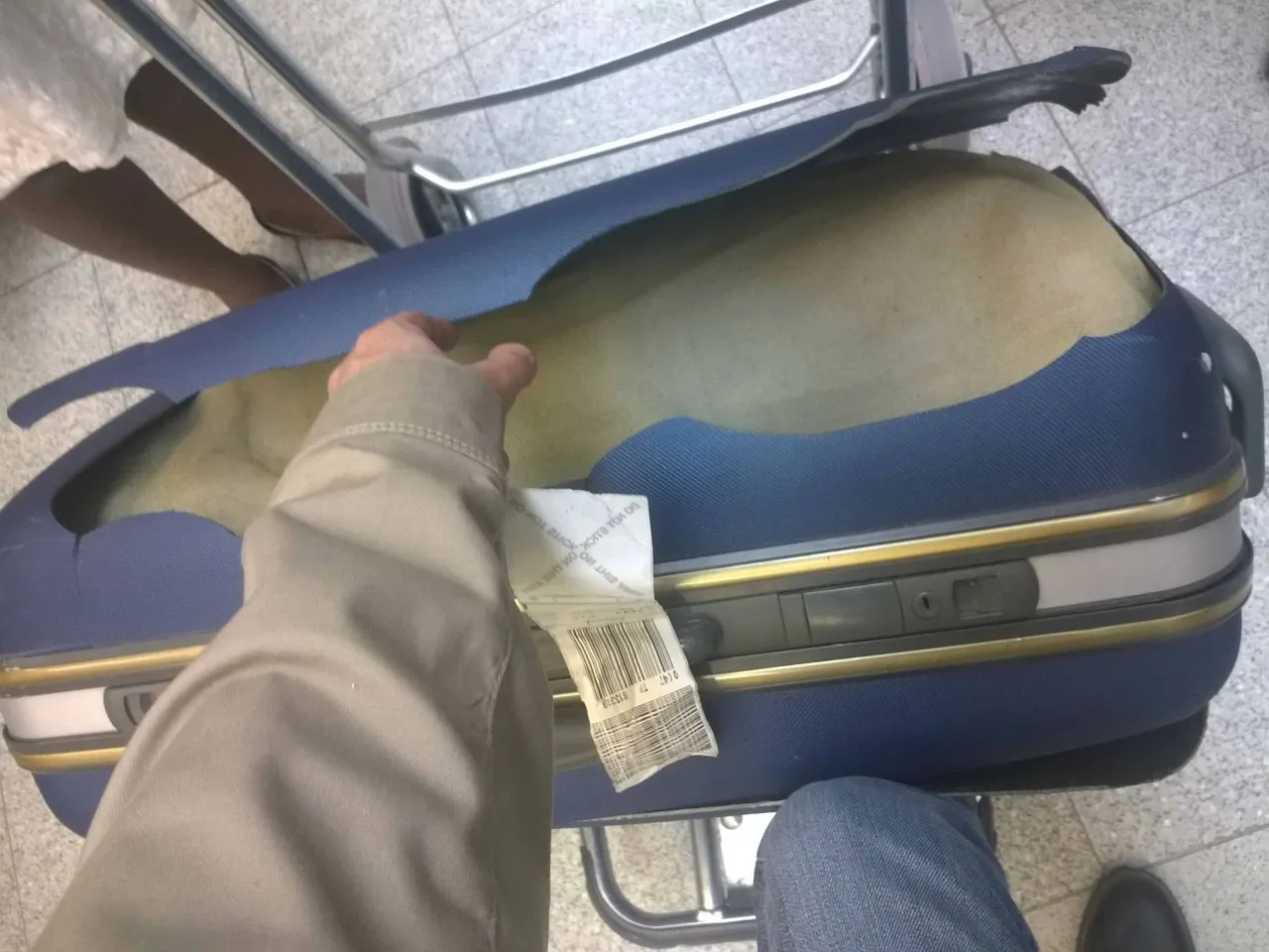 valise endommag&eacute;e sur un carrousel &agrave; bagages d'a&eacute;roport