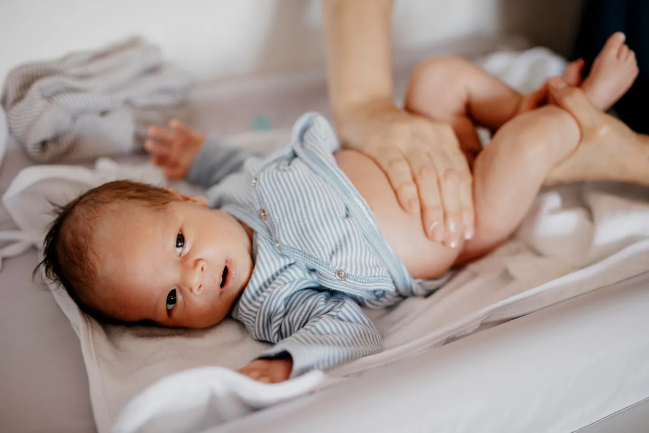 rodzic masujący brzuszek noworodka