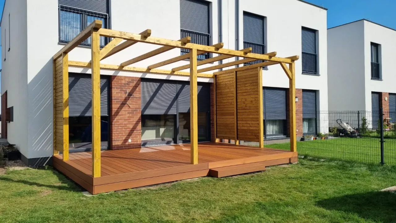 Drewniana pergola tarasowa, jak zrobić ją samemu? Oto inspiracja: przestronny taras z drewnianą pergolą i osłoną.