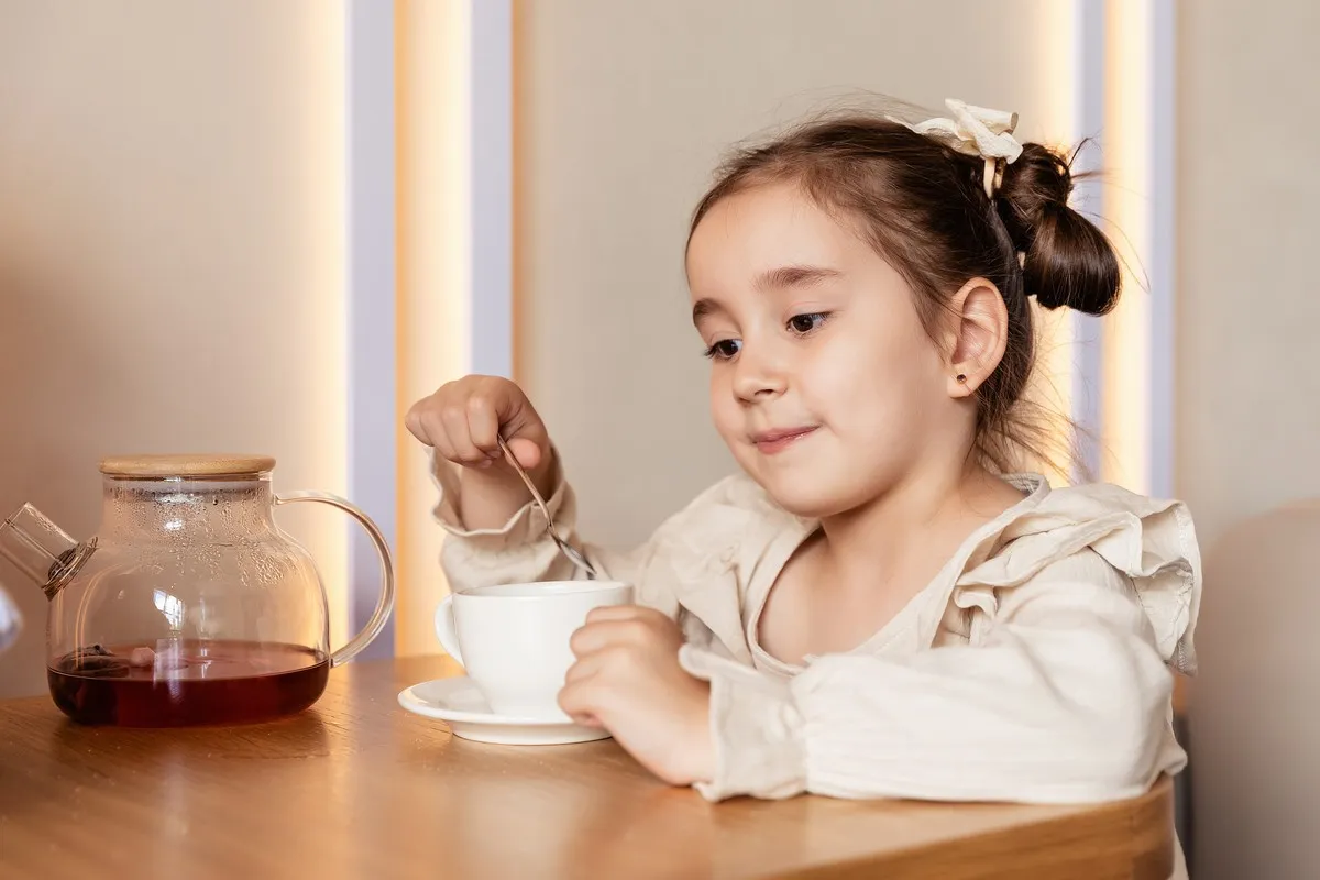 rodzic podający dziecku herbatkę w kubeczku