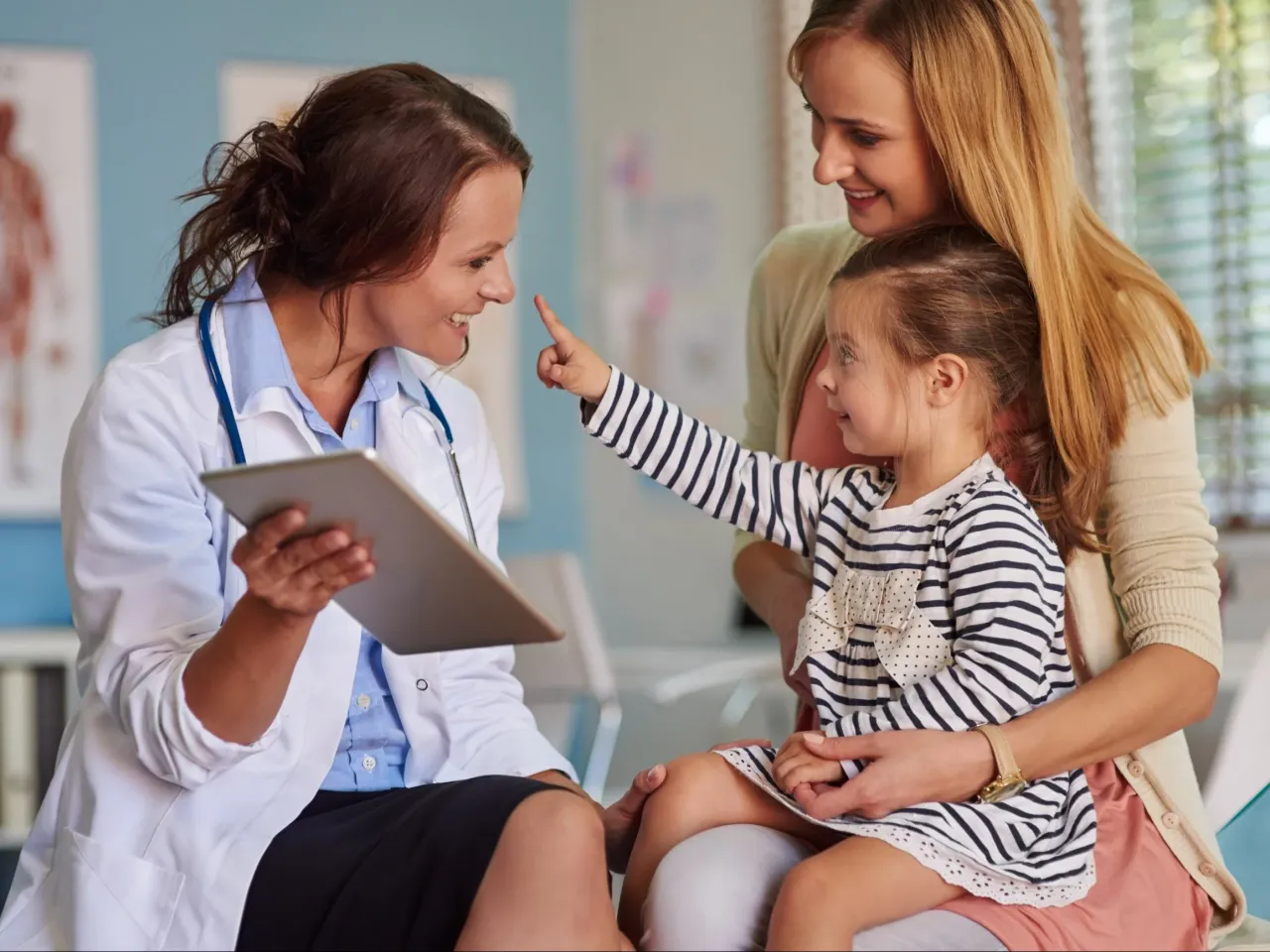 Rodzic z dzieckiem u lekarza, lekarz wypisuje zaświadczenie