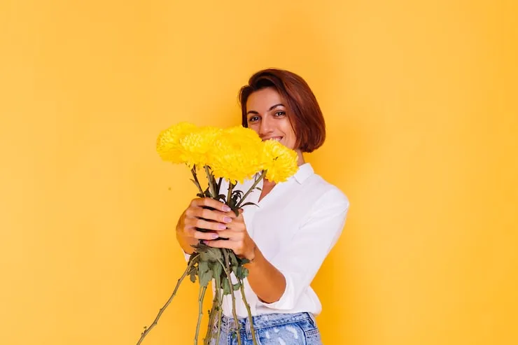 osoba wręczająca bukiet żółtych kwiatów na przyjęciu gratulacyjnym