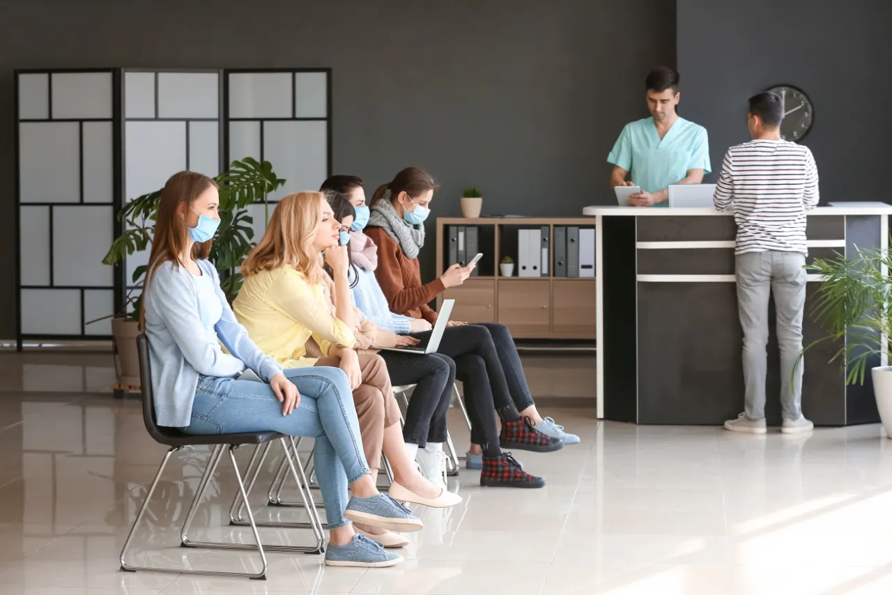 Poczekalnia w przychodni, ludzie siedzący spokojnie