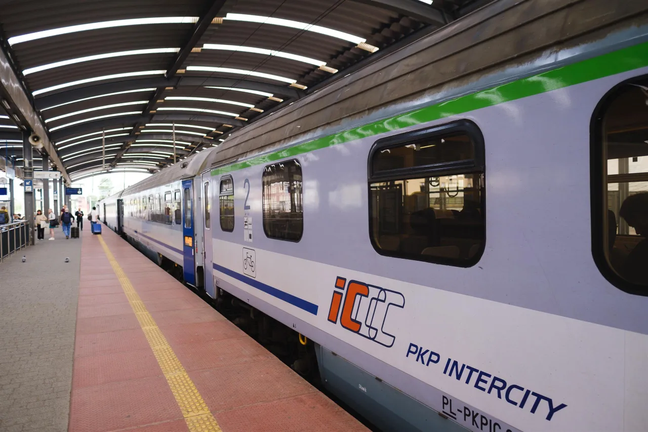 Pociąg PKP Intercity na peronie. Zastanawiasz się, ile kosztuje bilet TLK? Sprawdź ceny i zaplanuj podr&oacute;ż!