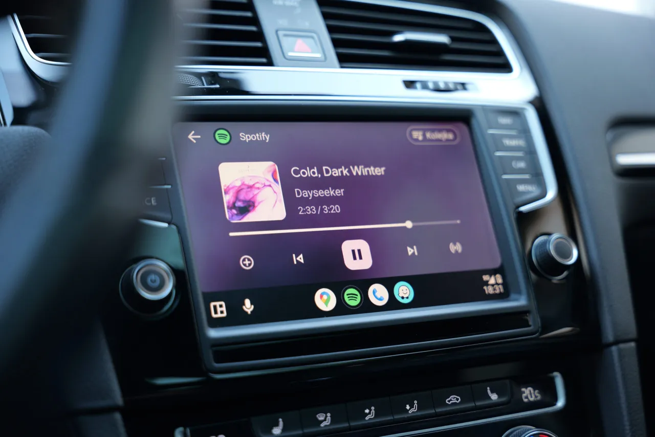 Ekran samochodu z Android Auto, odtwarzający Spotify. Widoczne ustawienia i ikony aplikacji.