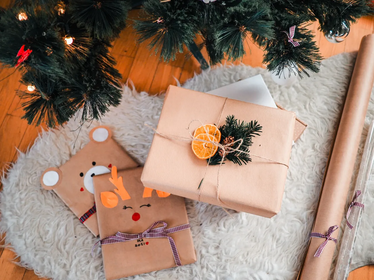 Jak oryginalnie zapakować prezent dla dziecka? Urocze paczki w kształcie misia i renifera pod choinką, ozdobione suszoną pomarańczą i gałązkami.